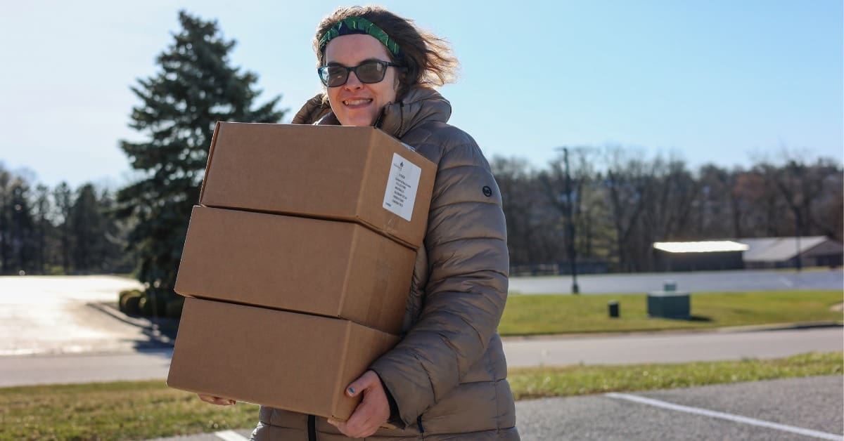 A TLC individual volunteers to carry boxes.